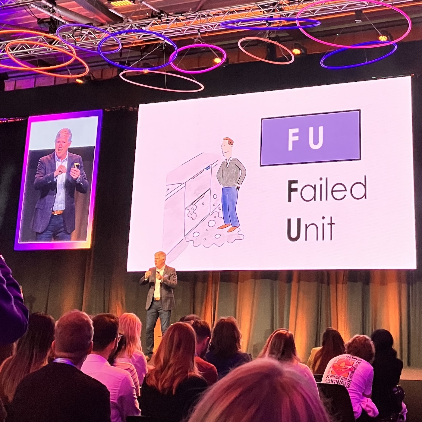 Tom Fishburne (Marketoonist) mit dem Thema "The Funny Side of Marketing: Avoiding The Customer Journey to Nowhere" präsentiert sein Comic über die Situation, als seine Spülmaschine auslief und das Display "F U" anzeigte für "Failed Unit". Als Kunde hat er aber gelesen "Fuck You".