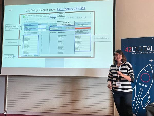 Foto aus Johannas Session auf der Campixx im Juni 2023. Johanna präsentiert ein Slide, auf dem ein Screenshot des von ihr gebauten Spreadsheets zur PixelRank Analyse abgebildet ist. Verschiedene Hinweise zu einzelnen Elementen und Bereichen sind eingezeichnet.