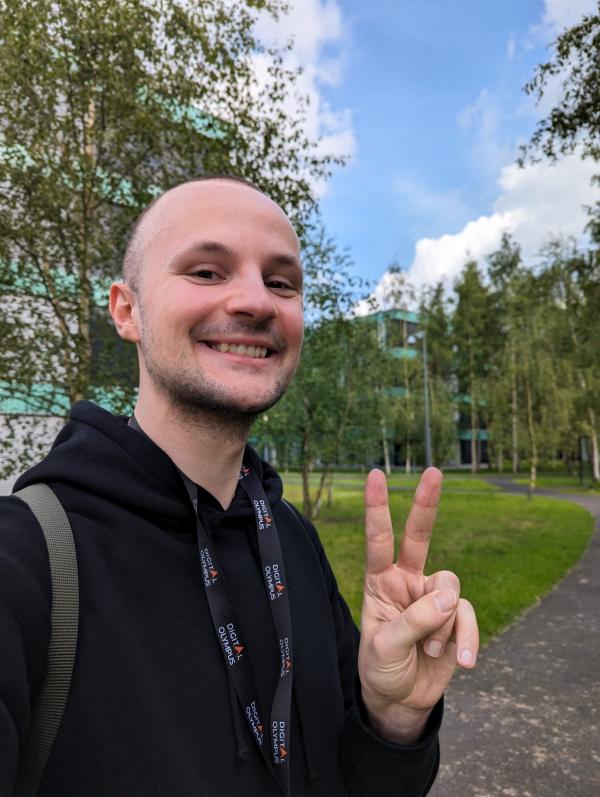 Philipp auf dem Campusgelände des HTC (wo die Konferenz stattfand). Er strahlt mit breitem Lächeln in die Kamera und fühlt sich wohl – vermutlich auch weil in der Umgebung viele Birkenbäume zu finden sind, seine Lieblingsbäume.